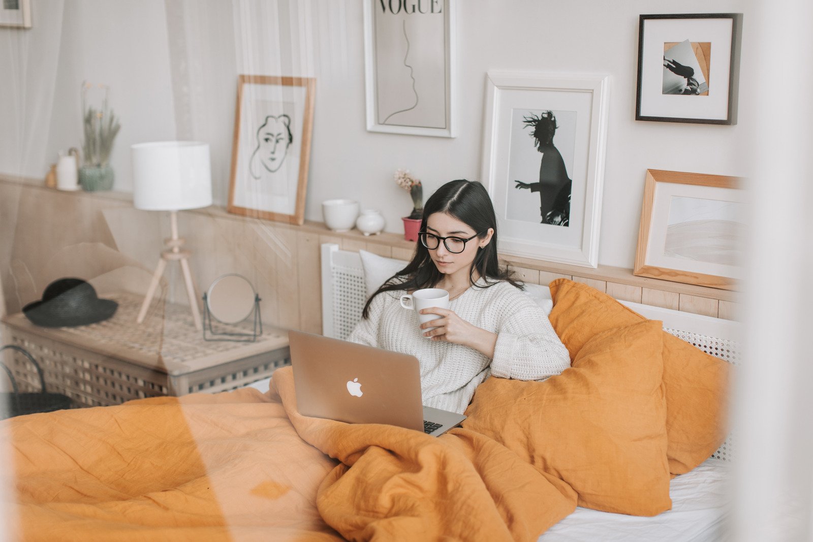 canva-thoughtful-woman-with-cup-of-drink-browsing-laptop-in-bed-MAD-ItMKKx4